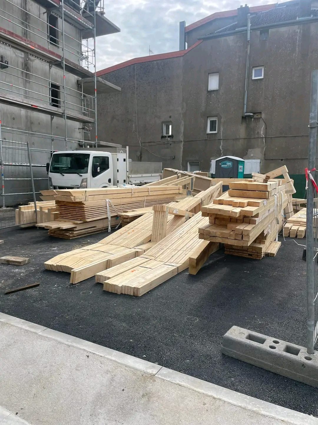 Bois de charpente empilé sur un chantier en ville